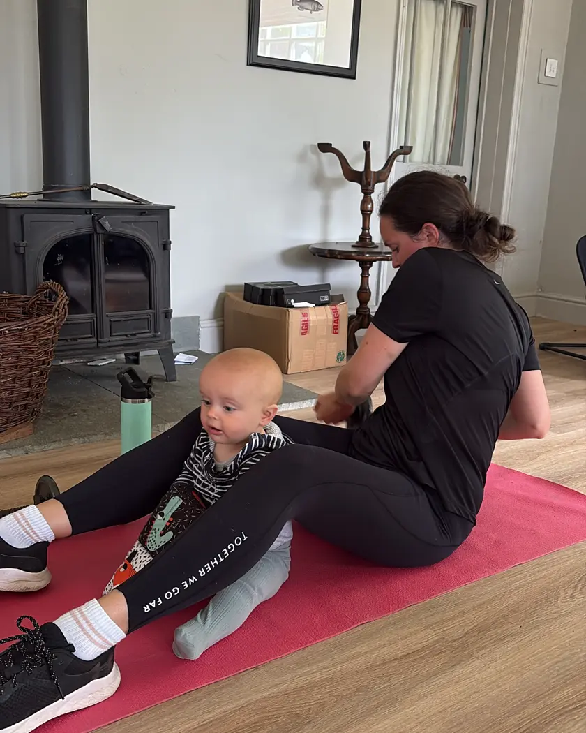 Home personal training session with a baby close by